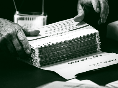 hands holding stack of ballots